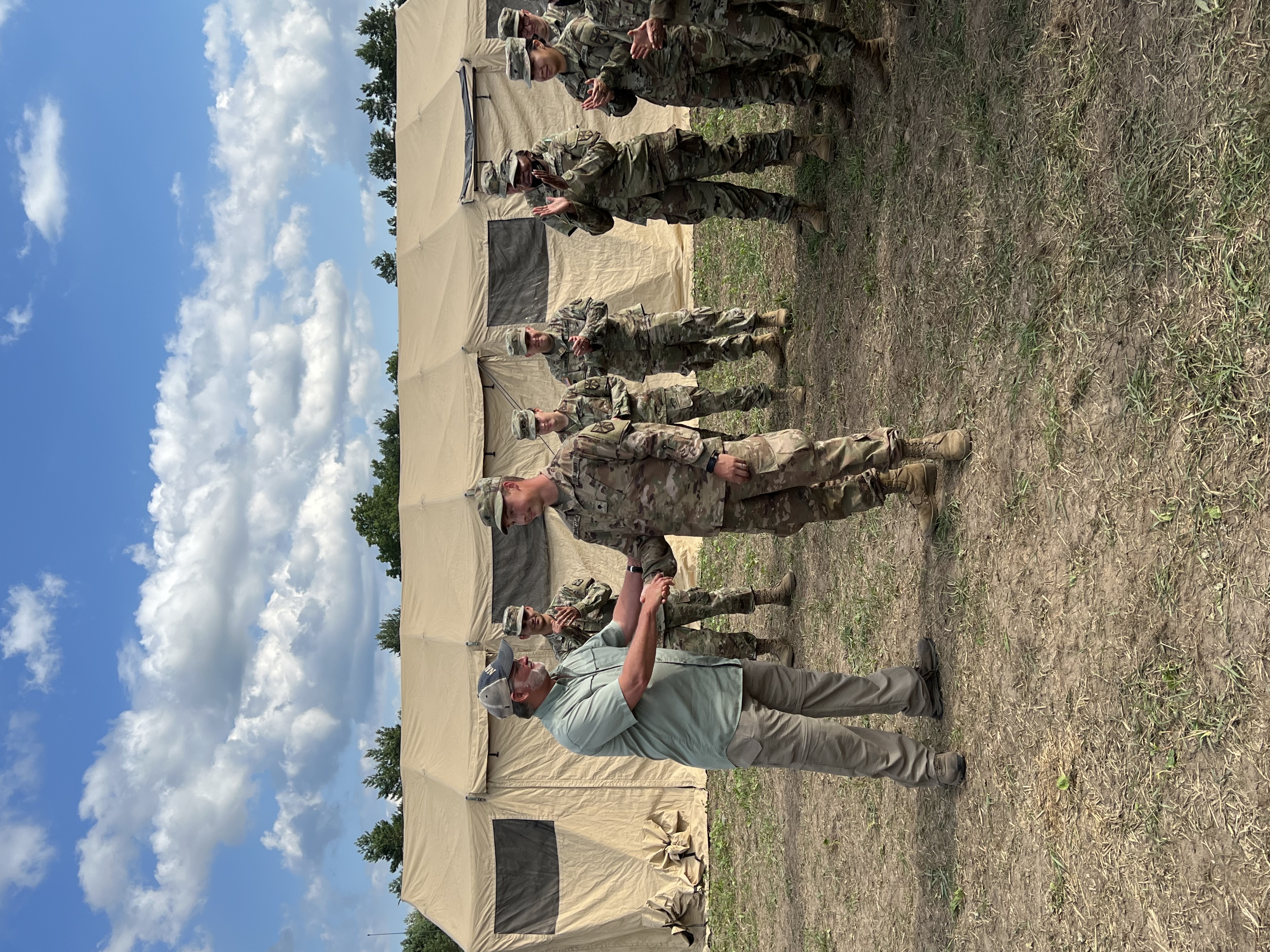 Peters Shaking army member's hand in front of army tent